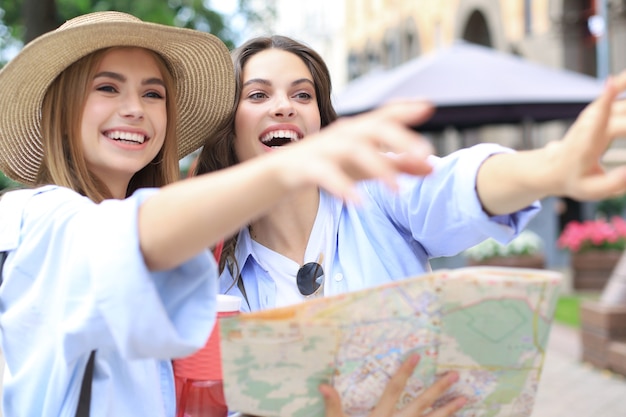 Férias e conceito de turismo - lindas garotas procurando uma direção na cidade.