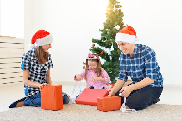 Férias e presentes conceito - retrato de uma família feliz abrindo presentes na época do Natal.