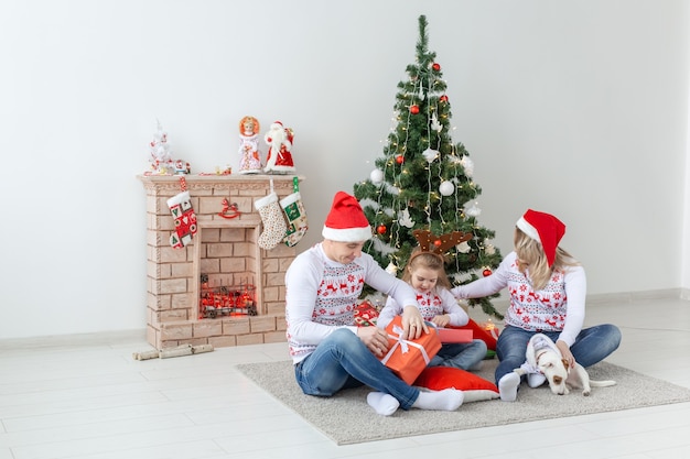 Férias e presentes conceito - retrato de uma família feliz abrindo presentes na época do natal.