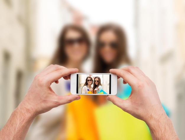 férias, eletrônica e conceito de turismo - close-up das mãos do homem tirando fotos com a câmera do smartphone