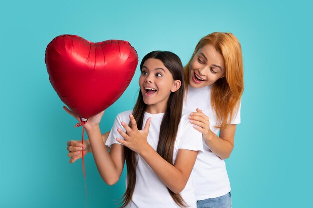 Férias em família Feliz dia das mães A filha da criança está parabenizando a mãe dando seu balão de coração Mãe