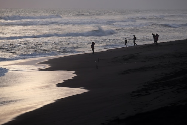 Férias em família na praia durante o pôr do sol no verão