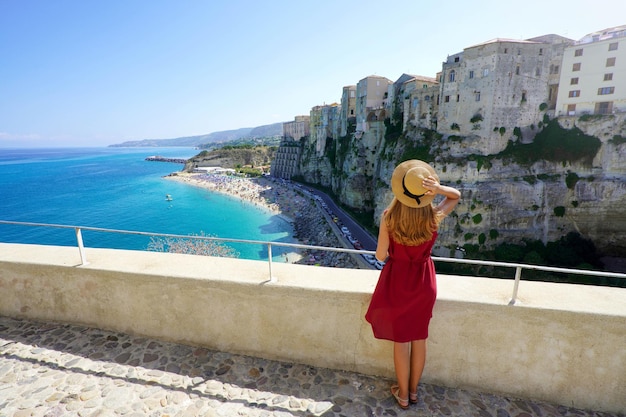 Férias em Tropea Itália Vista traseira de uma linda garota fashion apreciando a paisagem de Tropea Calabria Férias de verão na Itália