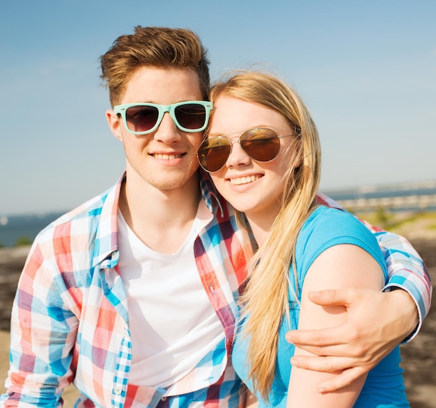 férias, férias, amor e conceito de amizade - casal sorridente se divertindo ao ar livre