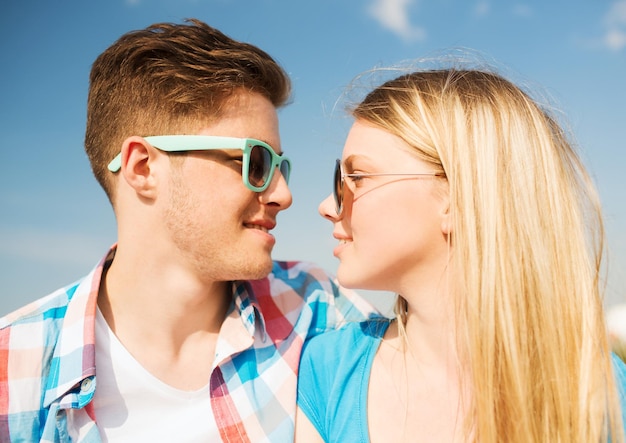 férias, férias, amor e conceito de amizade - casal sorridente se divertindo ao ar livre