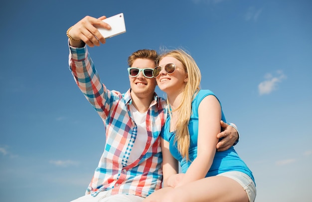 férias, férias, amor e conceito de amizade - casal sorridente se divertindo ao ar livre