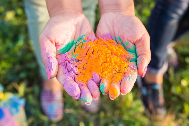 Férias indianas, diversão e conceito do festival Holi - palmas femininas cobertas de cores diferentes