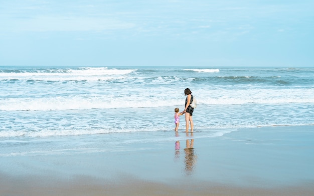 Férias, mãe e filha na praia, areia, segura a mão