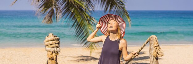 Férias na ilha tropical mulher de chapéu apreciando a vista para o mar do formato longo da bandeira da ponte de madeira