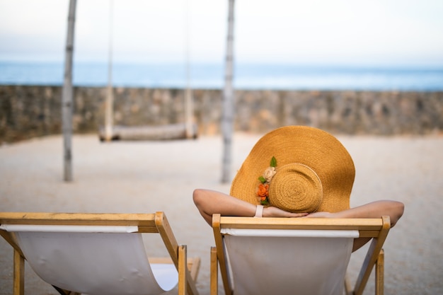 férias relaxantes férias de mulher relaxe alegremente descansando na cadeira de praia ao nadar