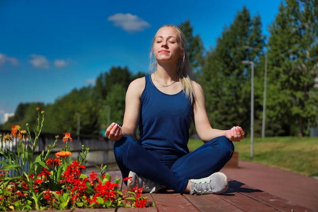 Ferienfrau, die Yoga-Posenmeditation im öffentlichen Park-Sport-gesundes Konzept tut.