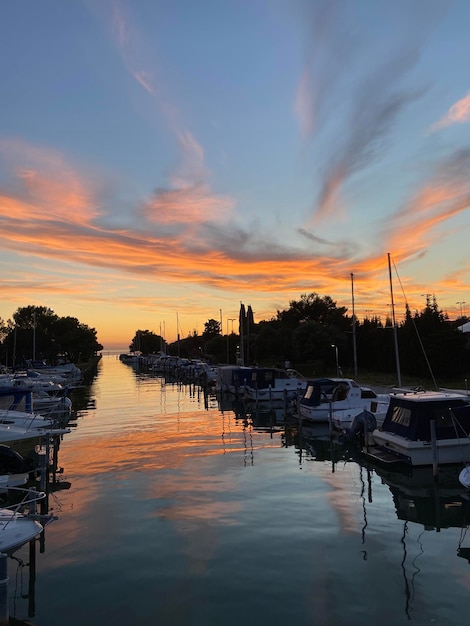 Ferienort an der slowenischen Küste. orangefarbener sonnenuntergangshimmel im sommer. Szenische Ansicht zum hölzernen Pier. Meer