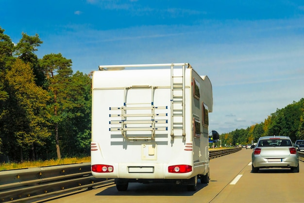 Ferienreise mit Caravan Car unterwegs in der Schweiz. Camper und Summer fahren auf der Autobahn. Urlaubsreise im Wohnmobil zur Erholung. Reisemobil-Minivan-Bewegungsfahrt. Landschaft mit Mini-Van-Fahrzeug