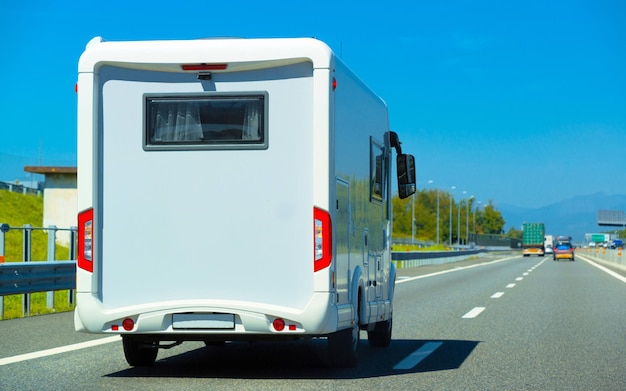 Ferienreise mit Caravan Car unterwegs in der Schweiz. Camper und Summer fahren auf der Autobahn. Urlaubsreise im Wohnmobil zur Erholung. Reisemobil-Minivan-Bewegungsfahrt. Landschaft mit Mini-Van-Fahrzeug