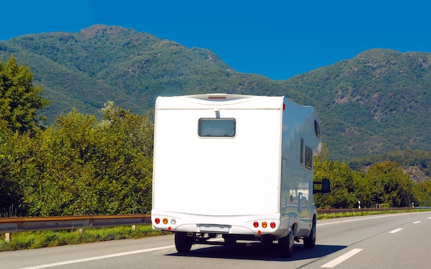 Ferienreise mit Caravan Car unterwegs in der Schweiz. Camper und Summer fahren auf der Autobahn. Urlaubsreise im Wohnmobil zur Erholung. Reisemobil-Minivan-Bewegungsfahrt. Landschaft mit Mini-Van-Fahrzeug