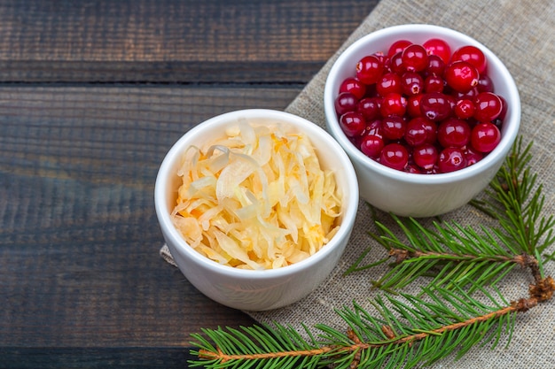 fermentierter Kohl mit Preiselbeeren in einer Schüssel auf rustikalem Holztisch