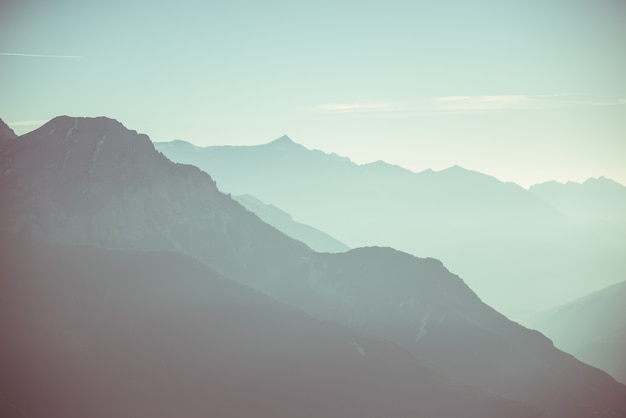 Ferne Berg Silhouette mit klarem Himmel und weichem Licht. Getontes Bild, Weinlesefilter, aufgeteiltes Tonen.