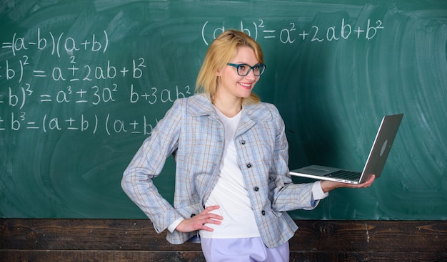 Fernunterrichtskonzept Lehrerin trägt eine Brille und hält einen Laptop, der im Internet surft