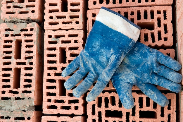 Foto ferramenta de construção para assentamento de tijolos e blocos ferramentas de pedreiro martelo espátula espátula luvas ferramentas manuais no fundo da alvenaria