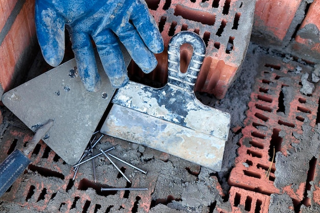 Ferramenta de construção para assentamento de tijolos e blocos Ferramentas de pedreiro martelo espátula espátula luvas Ferramentas manuais no fundo da alvenaria