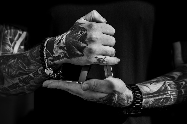 Foto ferramenta de corte de cabelo nas mãos de tatuagem do homem