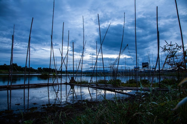 Ferramenta de pesca tradicional ou armadilha de peixe de bambu na silhueta da paisagem da luz do sol