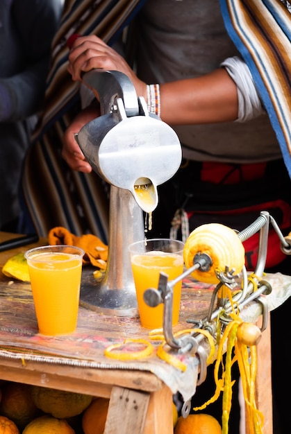 Ferramenta para fazer suco com laranja e copos na mesa