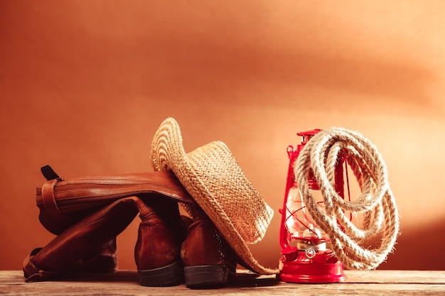 Ferramentas antigas de cowboy vintage - calçados de couro, stetson, corda e lâmpada de querosene