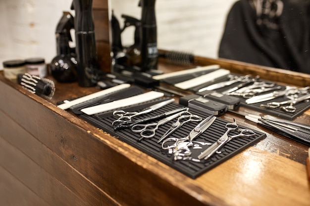 Foto ferramentas de barbeiro em prateleira de madeira e espelho em barbearia
