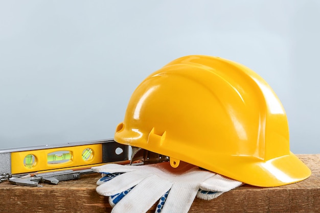 Ferramentas de construção e capacete em mesa de madeira