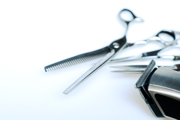 Ferramentas de corte de cabelo do barbeiro profissional em fundo branco.