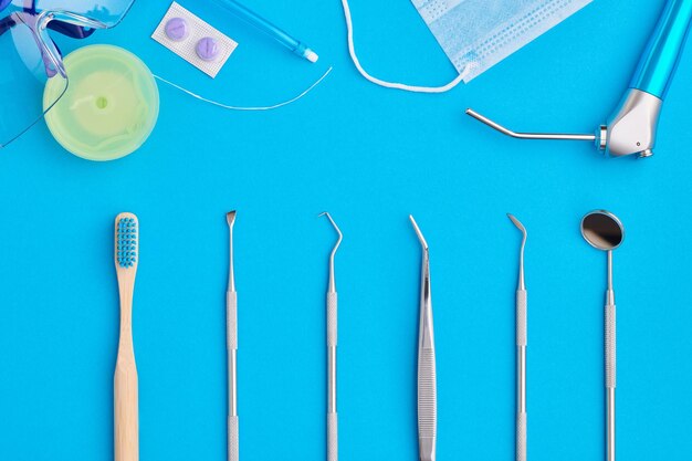 Ferramentas de dentista sobre a vista superior de fundo azul