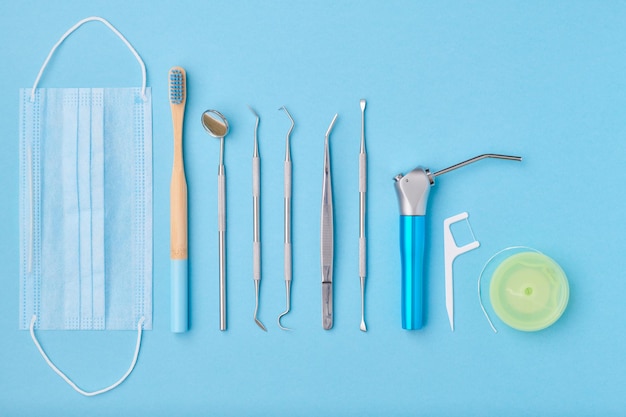 Foto ferramentas de dentista sobre a vista superior de fundo azul