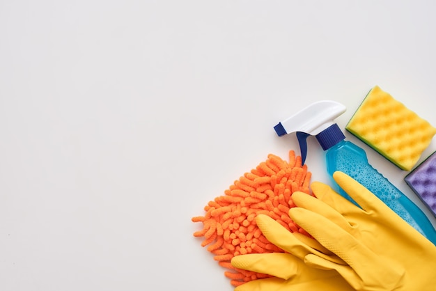 Foto ferramentas de limpeza. frasco de spray, esponjas de limpeza roxas e limpador isolado no fundo branco no canto direito da imagem