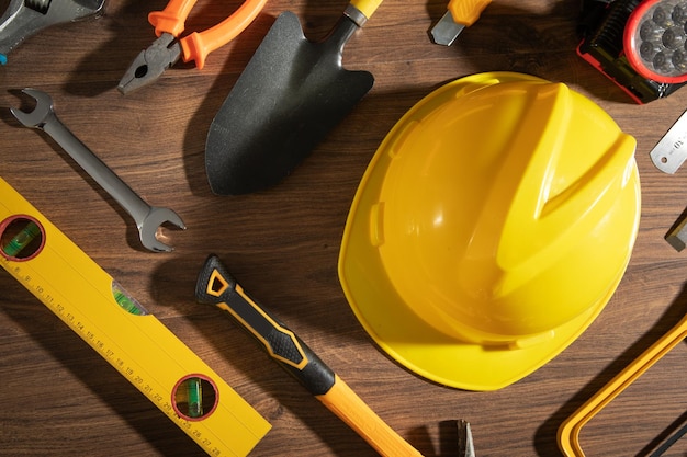 Ferramentas de trabalho com capacete em fundo de madeira