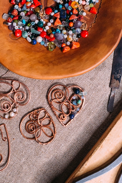 Ferramentas de trabalho feitas à mão em fio de cobre em cima da mesa com acessórios. conceito de arte de pessoas artesanato