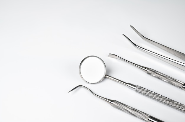 Foto ferramentas dentais em fundo branco. conceito de tecnologia médica. higiene dental. conceito de cura. ferramentas de dentista. equipamento dentário.