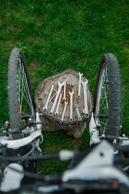 Ferramentas, instrumento para reparar a bicicleta no fundo de madeira ao ar livre perto de bicicleta