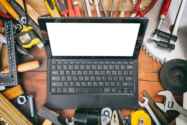 Foto ferramentas manuais e laptop em fundo de madeira