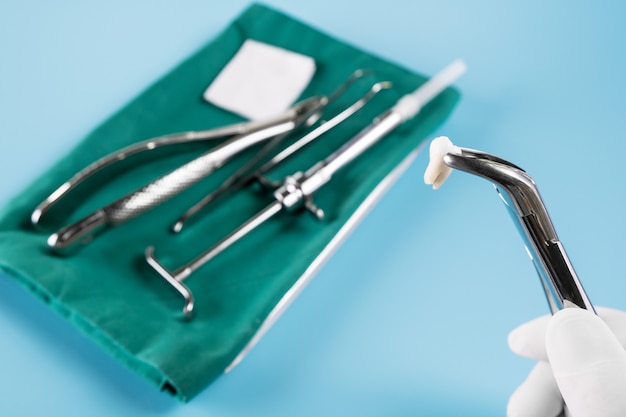 Foto ferramentas médicas de odontologia forceptam superior inferior sobre fundo azul