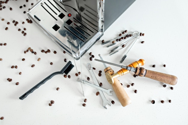 Ferramentas para reparar o close-up de máquinas de café. Grãos de café, placa de madeira, máquina de café, mesa de cozinha