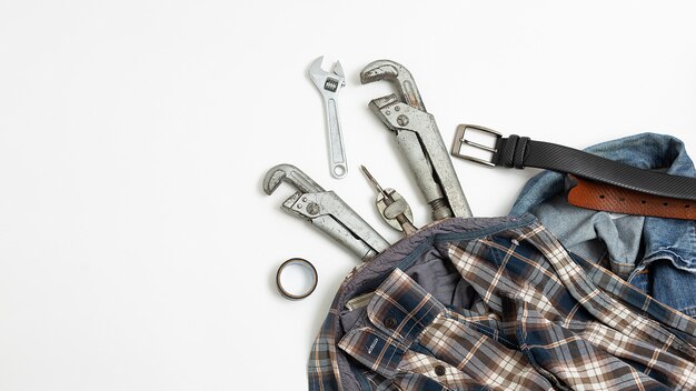 Ferramentas perto de camisa quadriculada, jeans, vista superior do cinto de couro. passatempo masculino lay plana