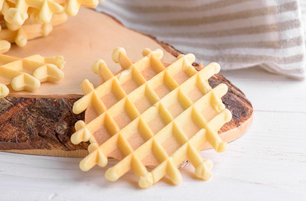 Ferratelle oder pizzelle ein traditionelles dessert oder kekse aus den abruzzen auf einem schneidebrett auf einem weißen