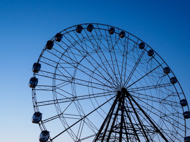 Ferris roda dentro um parque de diversões na do céu do por do sol. regime de luz.