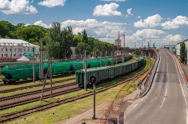 Ferrocarril con vagones de mercancías junto a una carretera