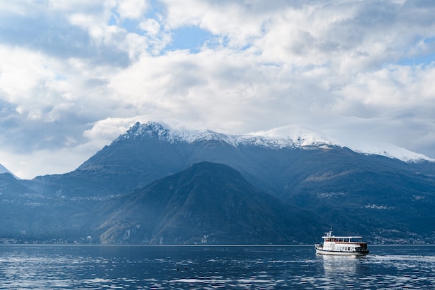 Ferry flota en el lago con el telón de fondo de las montañas de Italia como