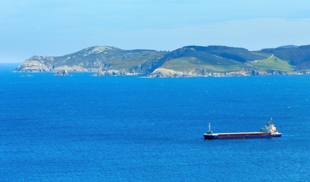 Ferry y paisaje de la costa de verano del océano Atlántico (Galicia, España).