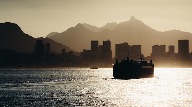 Ferry de pasajeros cruzando la Bahía de Guanabara con el distrito del centro de Río de Janeiro en segundo plano al atardecer Brasil