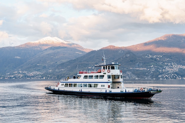 Ferry de pasajeros navega por la costa italiana del lago de como