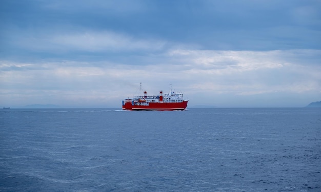 Ferry rojo en el mar ondulado cielo nublado azul Transporte en el mar Mediterráneo